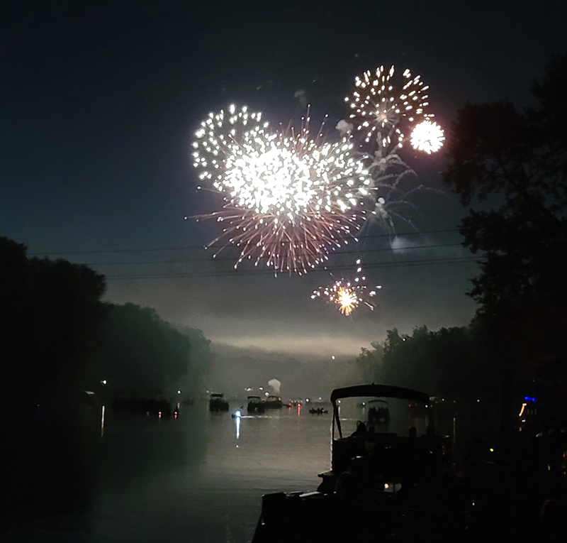 The light of the explosions lit up the boats in the river below.