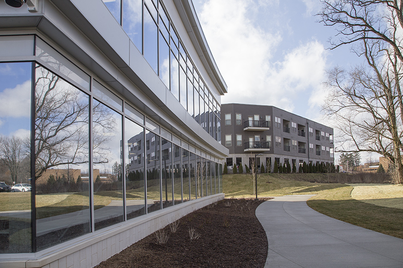 The river-facing wall of the Family Center, with The Ripple apartments behind.