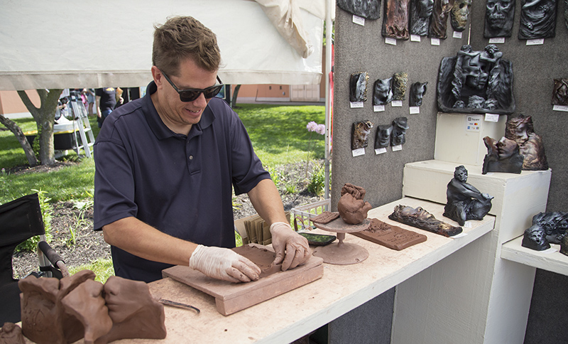Sculptor Sean Corner was sculpting at his tent