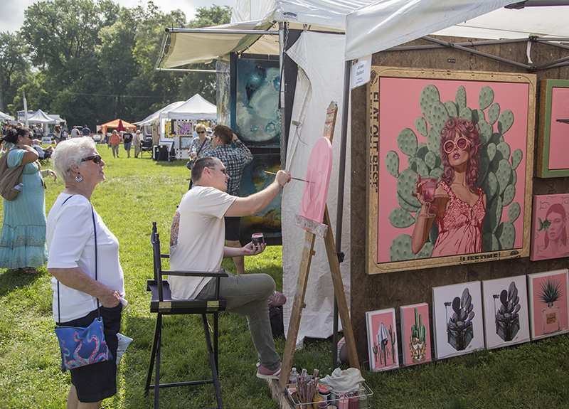 Jonah Ballard painting at his tent