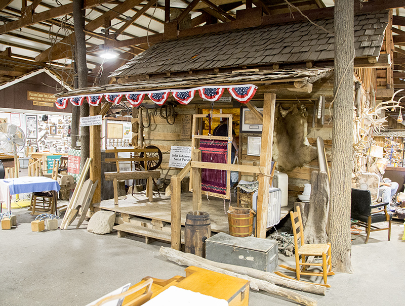 The John and Sarah Johnson replica log cabin in the Pioneer Village building.